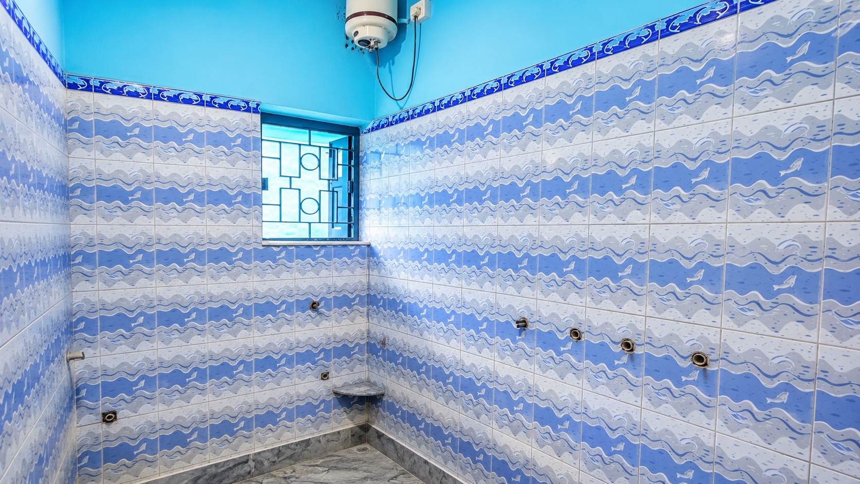 Bathroom before makeover with blue wall tiles