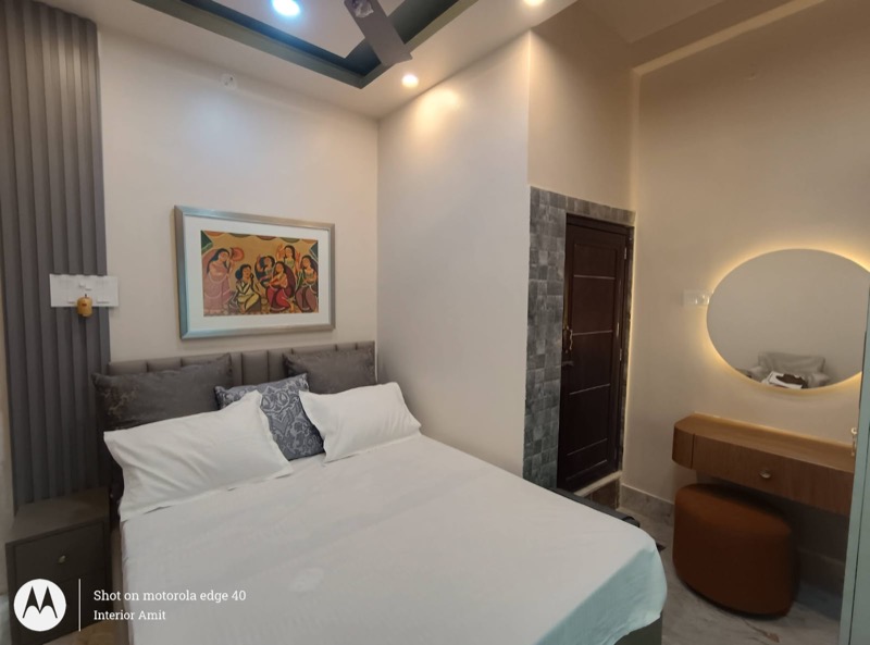 Neutral bedroom suite with bed, side table and warm lighting
