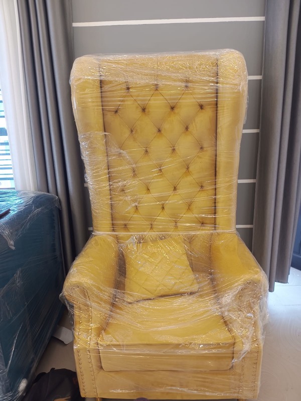 Tufted accent lounge chair beside curtain wall