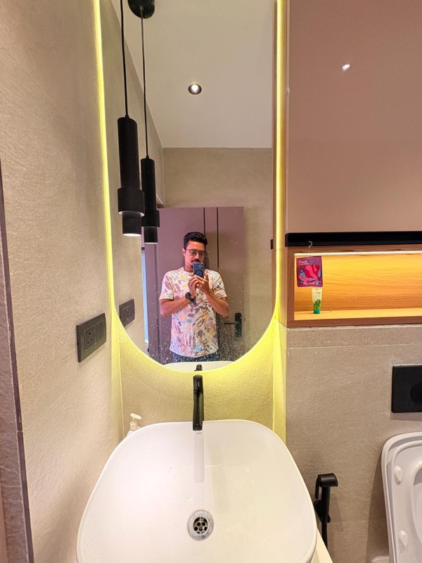 Bathroom interior with backlit oval mirror, pendant lights and modern vanity